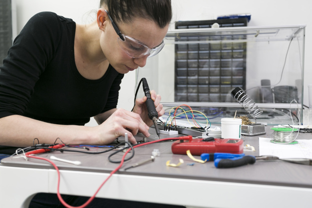 woman-soldering-pieces-table_23-2147778873